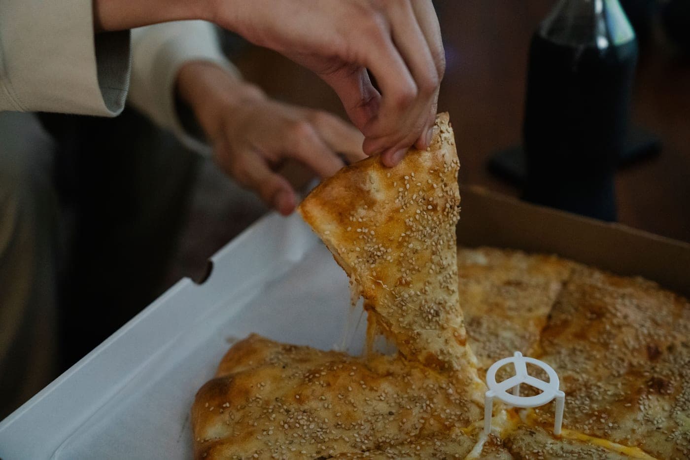 A slice of pizza held up, showing the underside