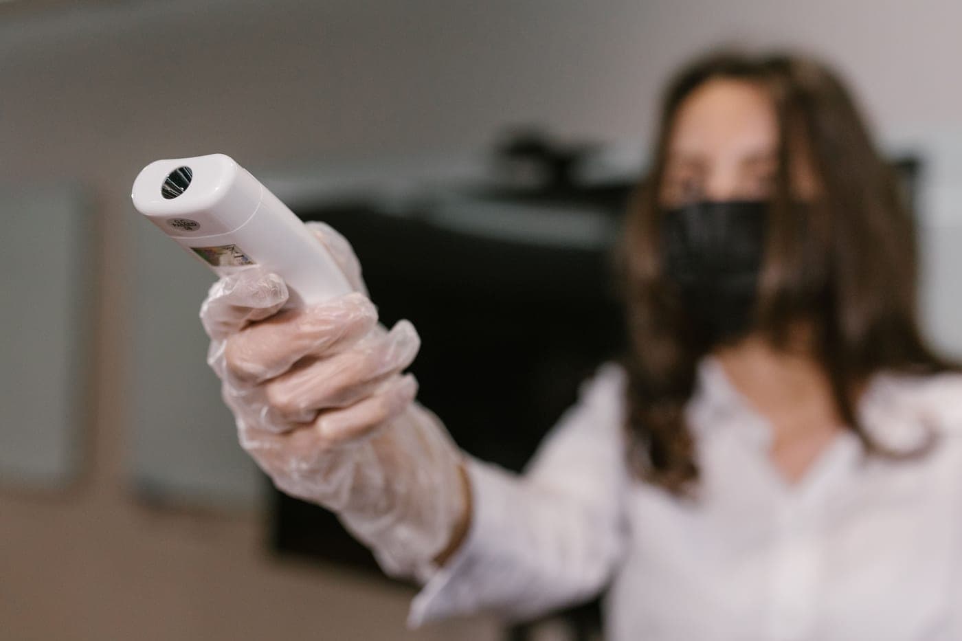 An infrared thermometer being used to read a surface temperature